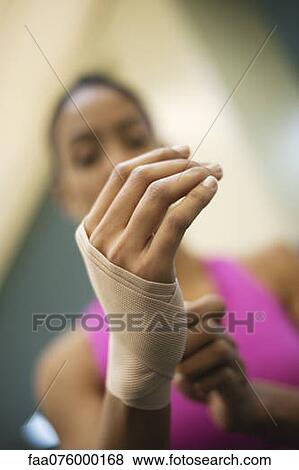Stock Photo - Woman with hand wrapped with bandage, low angle view. Fotosearch