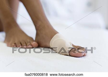 Stock Photo - Woman's foot wrapped in brace for injured toe, low section. Fotosearch