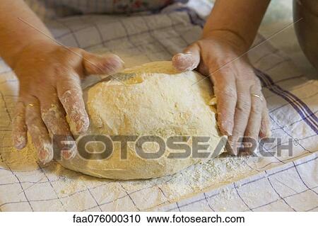 Stock Image - Woman's hands kneading pastry dough. Fotosearch