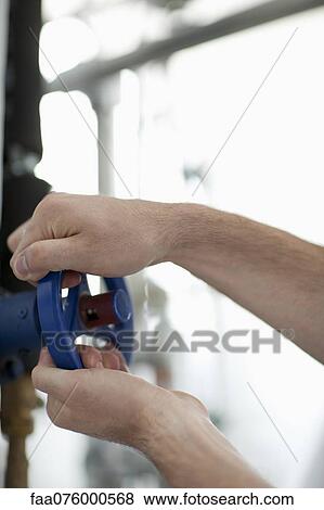 Worker adjusting valve on machine, cropped View Large Photo Image Stock Photo - Worker adjusting valve on machine, cropped. Fotosearch