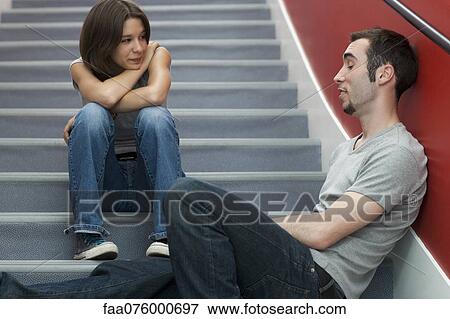Stock Photo - Young adult friends hanging out and chatting on stairs. Fotosearch