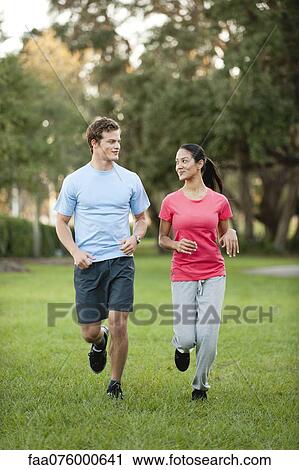 Stock Image - Young could jogging on grass. Fotosearch