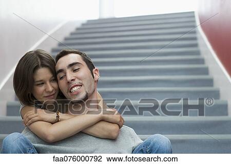Young couple sitting on stairs, embracing View Large Photo Image Stock Image - Young couple sitting on stairs, embracing. Fotosearch