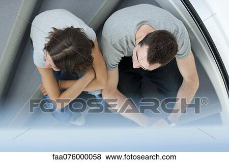 Stock Photo - Young couple sitting together on steps, overhead view. Fotosearch