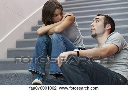 Stock Image - Young couple talking together on stairs. Fotosearch