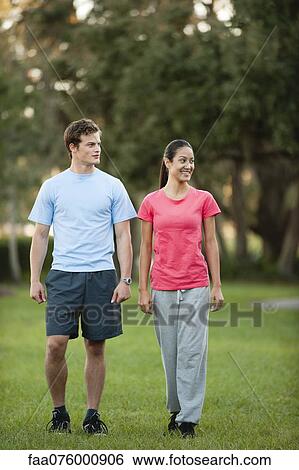 Stock Photograph - Young couple walking in park. Fotosearch