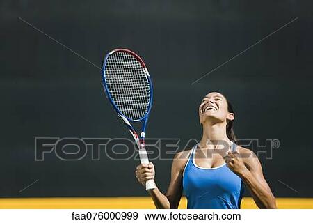 Stock Photo - Young female tennis player cheering, portrait. Fotosearch