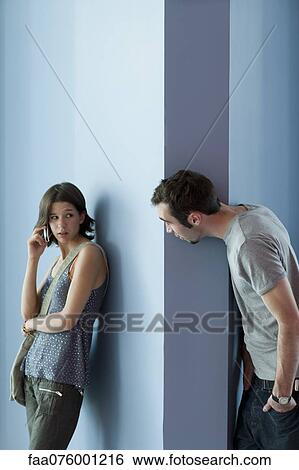 Stock Photograph - Young man interrupting young woman's cell phone call. Fotosearch