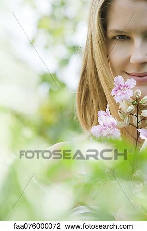 Stock Image - Young woman and flowers, selective focus. Fotosearch