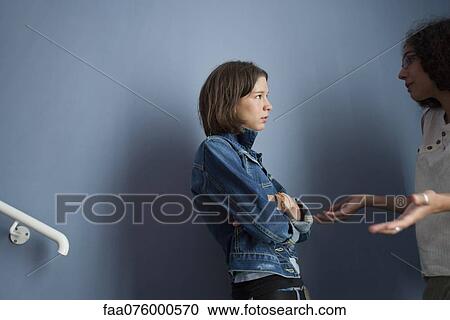 Stock Image - Young woman apologizing to upset friend. Fotosearch