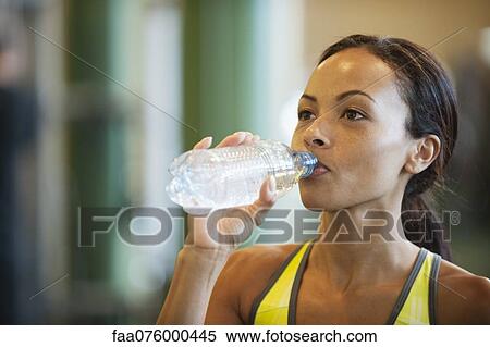 Young woman drinking bottle of water View Large Photo Image Stock Photography - Young woman drinking bottle of water. Fotosearch