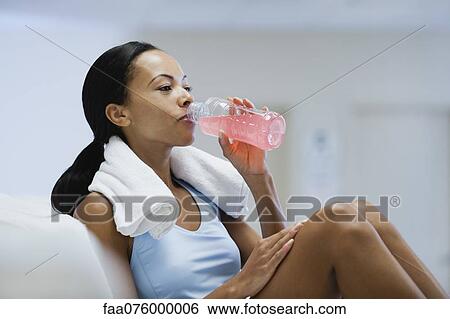 Stock Photograph - Young woman drinking sports drink. Fotosearch