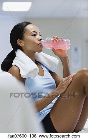 Stock Photograph - Young woman drinking sports drink. Fotosearch