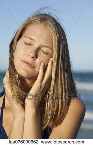 Stock Image - Young woman in bikini with eyes closed, portrait. Fotosearch