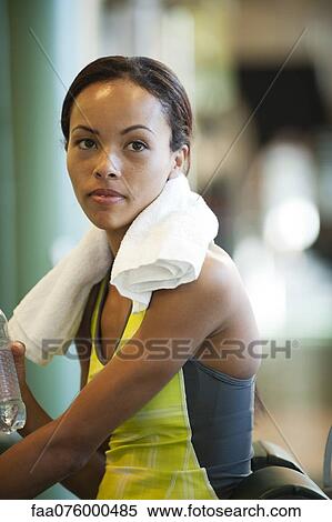 Stock Photography - Young woman in sports clothing with towel around neck. Fotosearch