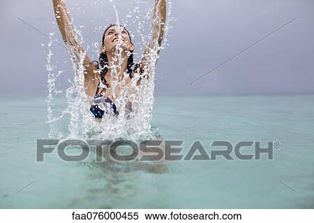 Young woman splashing in water View Large Photo Image Stock Photography - Young woman splashing in water. Fotosearch