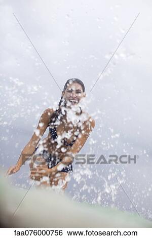 Stock Photograph - Young woman splashing water. Fotosearch