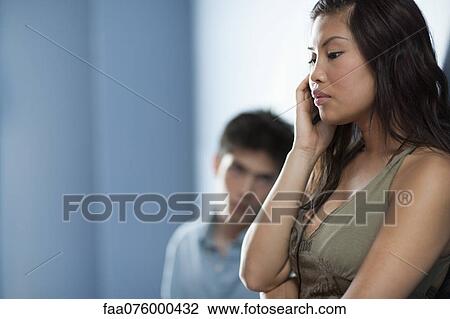 Stock Image - Young woman talking on cell phone. Fotosearch