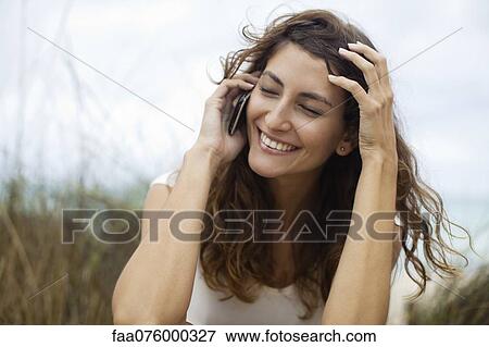 Stock Photo - Young woman talking on cell phone. Fotosearch
