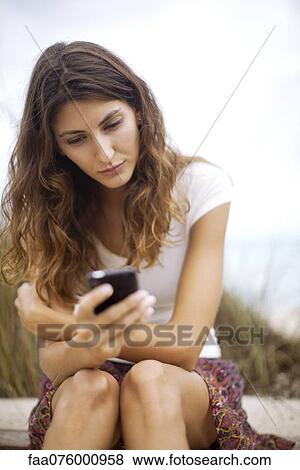 Young woman text messaging with cell phone View Large Photo Image Stock Photo - Young woman text messaging with cell phone. Fotosearch