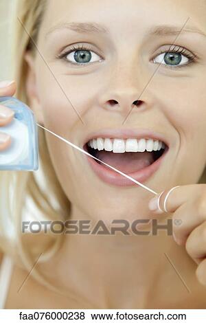 Young woman using dental floss View Large Photo Image Stock Photo - Young woman using dental floss. Fotosearch