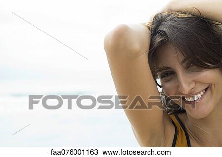 Stock Image - Young woman with hands in hair, cropped. Fotosearch