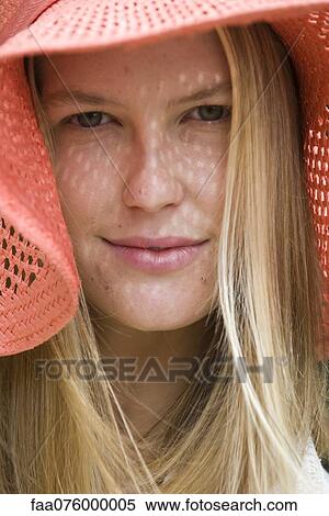 Stock Photography - Young woman with straw hat, portrait. Fotosearch