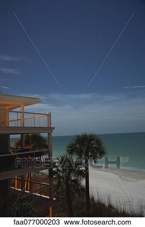 Stock Image - Apartment building on beach at twilight. Fotosearch