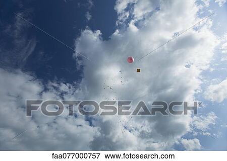 Stock Photo - Balloon with message attached to it floating in sky. Fotosearch