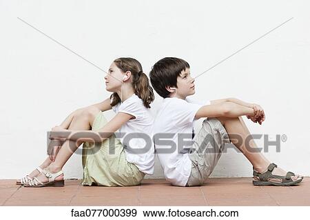 Boy and girl sitting back to back listening to music together View Large Photo Image Stock Photo - Boy and girl sitting back to back listening to music together. Fotosearch