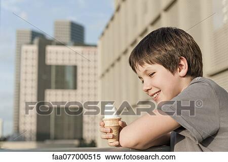 Stock Photography - Boy holding ice cream cone, portrait. Fotosearch
