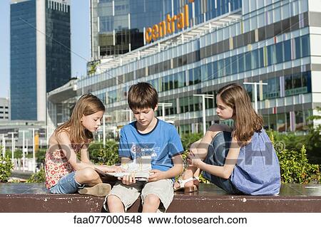 Stock Photo - Children reading map in city. Fotosearch