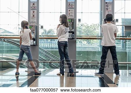 Stock Photo - Children using payphones. Fotosearch