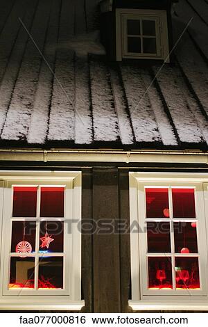 Stock Photograph - Christmas decorations hanging in window of house at night. Fotosearch