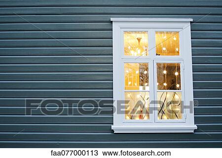 Stock Image - Christmas lights hanging in widow. Fotosearch