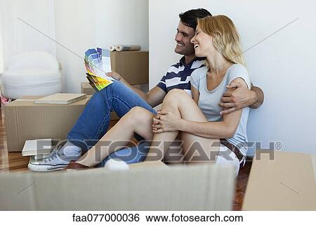 Stock Photograph - Couple discussing color swatches in new house. Fotosearch