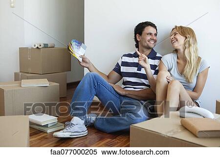 Stock Photography - Couple discussing color swatches in new house. Fotosearch