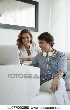 Stock Photo - Couple looking at laptop computer. Fotosearch