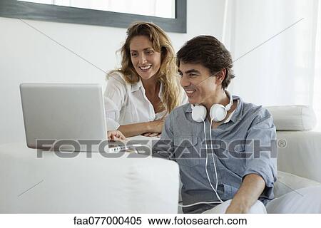 Couple looking at laptop computer View Large Photo Image Stock Photography - Couple looking at laptop computer. Fotosearch