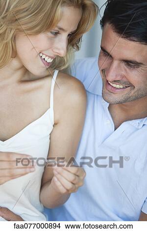 Picture - Couple looking at pregnancy test, smiling. Fotosearch