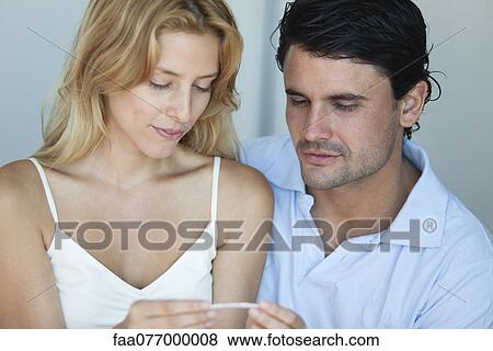 Stock Photo - Couple looking at pregnancy test. Fotosearch