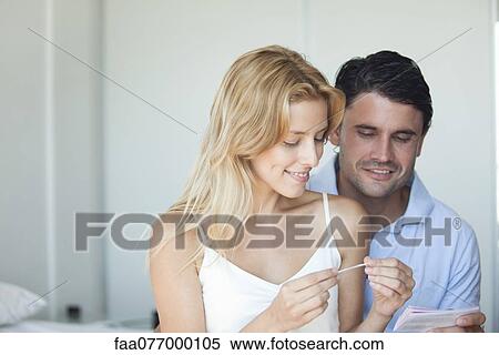 Stock Photography - Couple looking at pregnancy test. Fotosearch