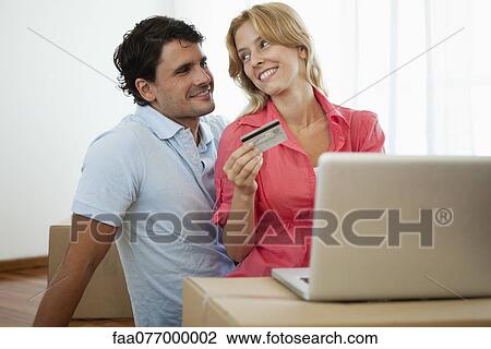 Stock Image - Couple shopping online for their new home. Fotosearch