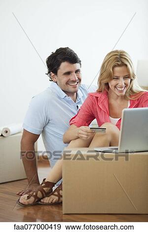 Stock Photo - Couple shopping online for their new home. Fotosearch