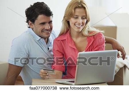 Couple shopping online for their new home View Large Photo Image Stock Photo - Couple shopping online for their new home. Fotosearch