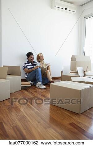 Couple unpacking cardboard boxes in new house View Large Photo Image Stock Image - Couple unpacking cardboard boxes in new house. Fotosearch