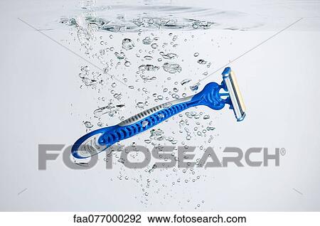 Stock Image - Disposable razor submerged in water. Fotosearch