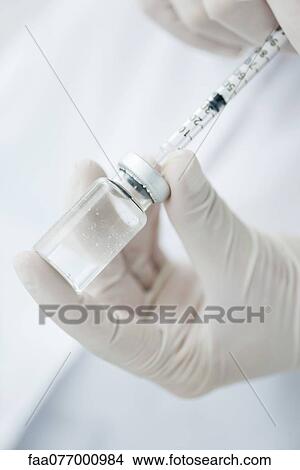 Extracting liquid from vial with syringe View Large Photo Image Picture - Extracting liquid from vial with syringe. Fotosearch