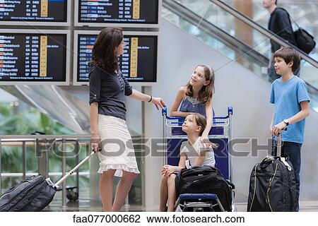Family in airport with luggage View Large Photo Image Stock Image - Family in airport with luggage. Fotosearch