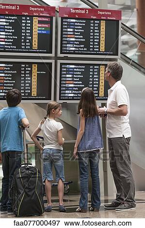 Family looking at arrival departure board, rear view View Large Photo Image Stock Photo - Family looking at arrival departure board, rear view. Fotosearch